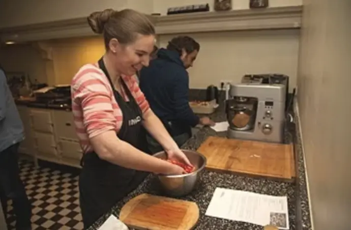 Gasten bereiden samen een gerecht in de keuken
